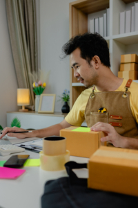 An entrepreneur is working in a warehouse preparing packages for delivery drivers to pick up and deliver to customers, parcel, product, package, startup business, merchandise
